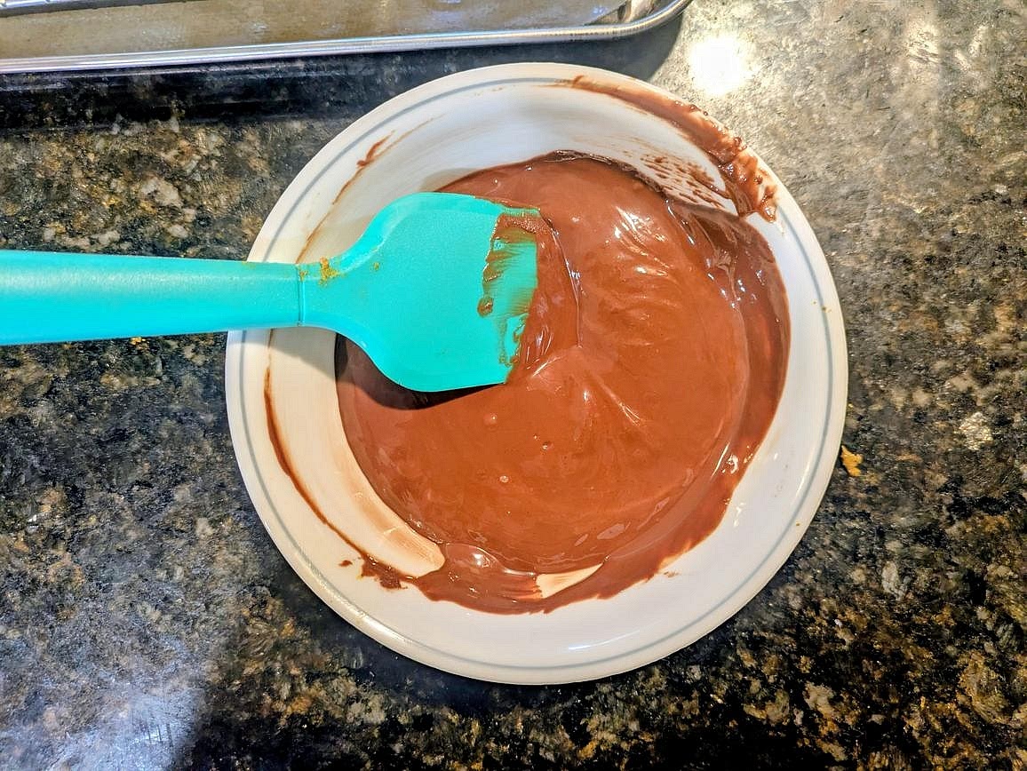 Add chocolate chips and coconut oil to a medium bowl. Microwave in 20 second intervals, stirring in between with a silicone spatula, until you have a smooth melted chocolate