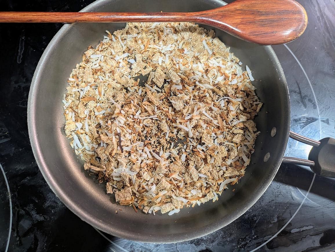 Roughly chop your wheat cereal to make a shredded crumb. Add to a medium pan over medium heat with the coconut flakes. Toast for about 5 minutes, or until lightly browned and fragrant. Set aside
