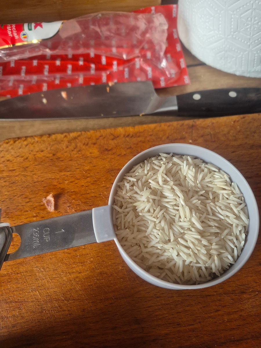 Am oprit plita, am adaugat orezul, apa, pasta de rosii si condimentele. Am pornit plita la maxim (2000 "Boil") pana incepe sa fiarba, apoi reduc plita aproape de minim (800), cat sa continuie sa fiarba apa dar sa nu stropeasca si las sa fiarba cate minute scrie pe punga de orez (am pus orez basmati pe care scrie 12 minute maxim si orez negru pe care scrie 12-14 minute). Voi fierbe orezul 12 minute. Amestec din cand in cand