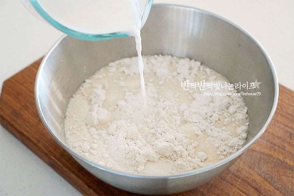 가루가 담긴 볼에 섞은 우유물을 넣어요. 막걸리를 먼저 넣어줍니다. 생막걸리라고 적인 걸 넣으셔야 반죽이 발효가 됩니다. 저는 지평*생막걸리 넣어서 만들었어요. 냉장고에서 미리 꺼내두어 냉기를 빼준 뒤 넣었어요. 가루에 따라 수분의 양이 다를 수 있어 한 번에 다 넣지 않고 넣어가며 농도를 맞추어주세요. 저는 건식 가루라 수분을 조금 더 넉넉히 넣어주었어요. 날가루가 보이지 않게 잘 섞어줍니다. 반죽 농도는 묽은 듯 걸쭉한 정도입니다.