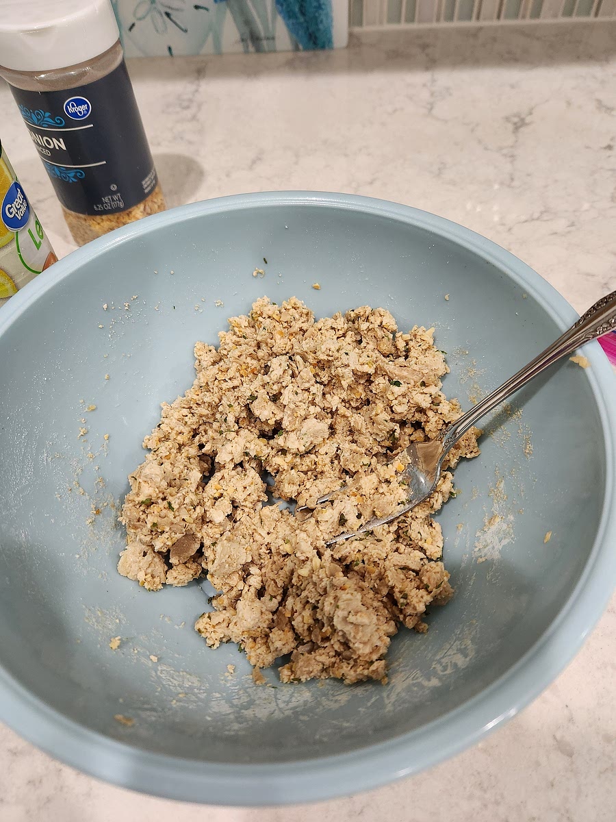 Mix vegan tuna with crushed saltines, flour, and dried minced onion. Add the lemon juice and mix well. Sprinkle in some dried parsley and mix.