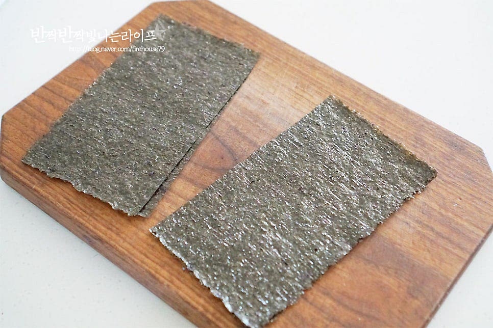 김은 가위를 사용하여 반으로 잘라요. 크기에 따라 4등분 해도 되는데 속 재료를 큼직하게 넣어줄 것이라 2등분으로 터지지 않게 말아주었어요.