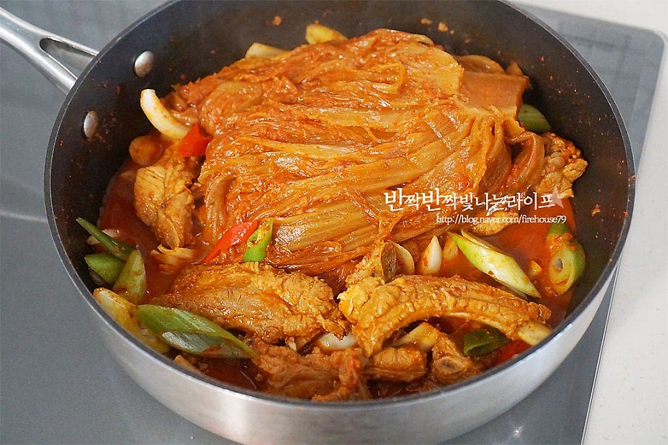 40분 정도 끓이니 국물 자작하게 김치가 쭉 찢어질 정도로 부드럽게 익었어요. 대파, 양파, 고추를 넣고 한소끔 끓여 완성해요.