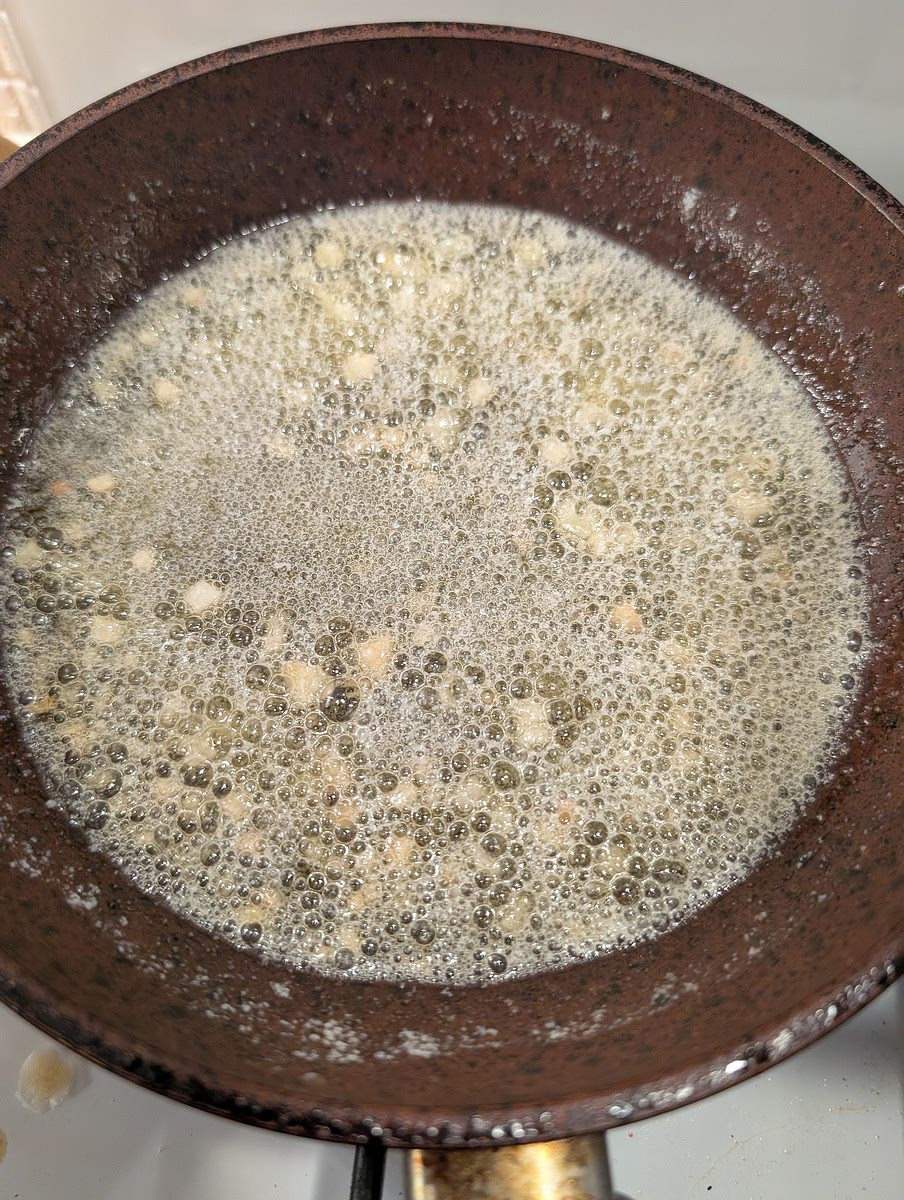 While this happens, in a frying pan melt the butter and gently fry the sliced garlic. Both should be golden but not burnt, so keep an eye on them.