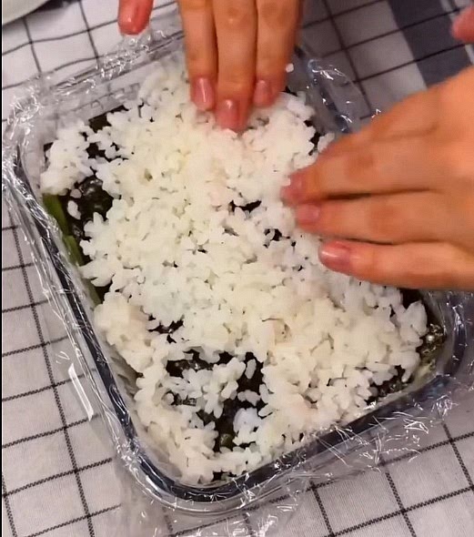 pon una lámina de alga nori y encima pon el arroz y pon la ultima alga nori