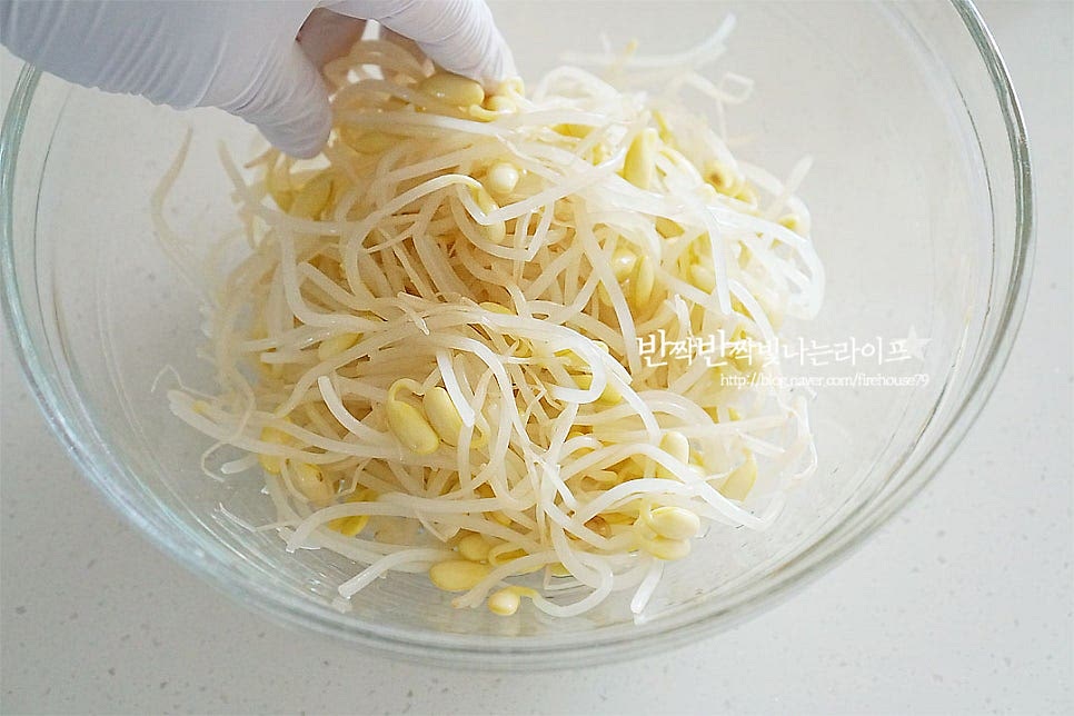 넉넉한 크기의 볼에 콩나물을 넣어줍니다. 참치액 1 작은 술, 국간장 1 작은 술 간 마늘 1 작은 술, 다진 파 1 큰 술 참기름 1 큰 술, 깨소금 1 큰 술을 넣어줍니다. 참기름과 함께 깨소금을 넣으면 고소하게 풍부한 맛을 낼 수 있으며 참치액과 국간장을 섞어 넣으면 감칠맛이 더욱 깊어집니다. 어린아이들 반찬이라면 맵게 느낄 수 있는 마늘과 대파는 생략 가능해요. 간이 밸 수 있도록 무쳐줍니다. 간혹 쓴맛이 느껴질 때는 설탕 한 꼬집 넣으면 쓴맛을 잡을 수 있으며 부족한 간은 소금으로 더해주세요.