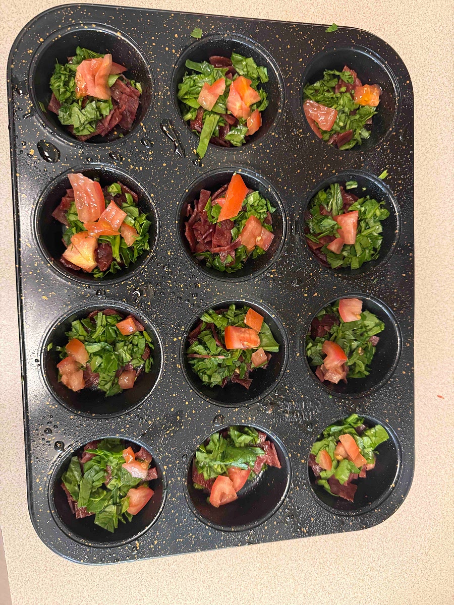 Cook and chop bacon. Chop spinach and tomatoes. Grease muffin tin. Put bacon, spinach and eggs in muffin tins. Preheat oven to 350 degrees.