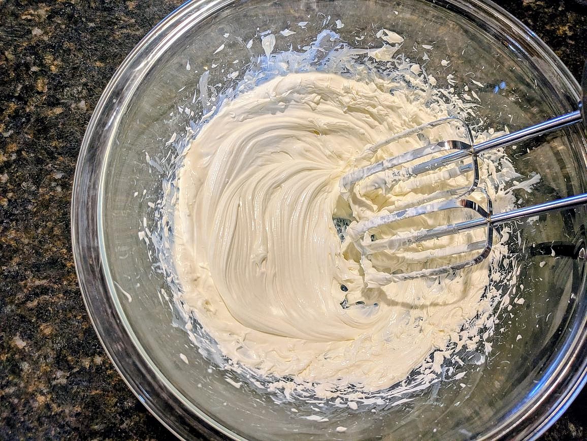 In a large glass bowl, beat the cream cheese with a hand mixer on high speed for about 5 minutes to soften and incorporate air