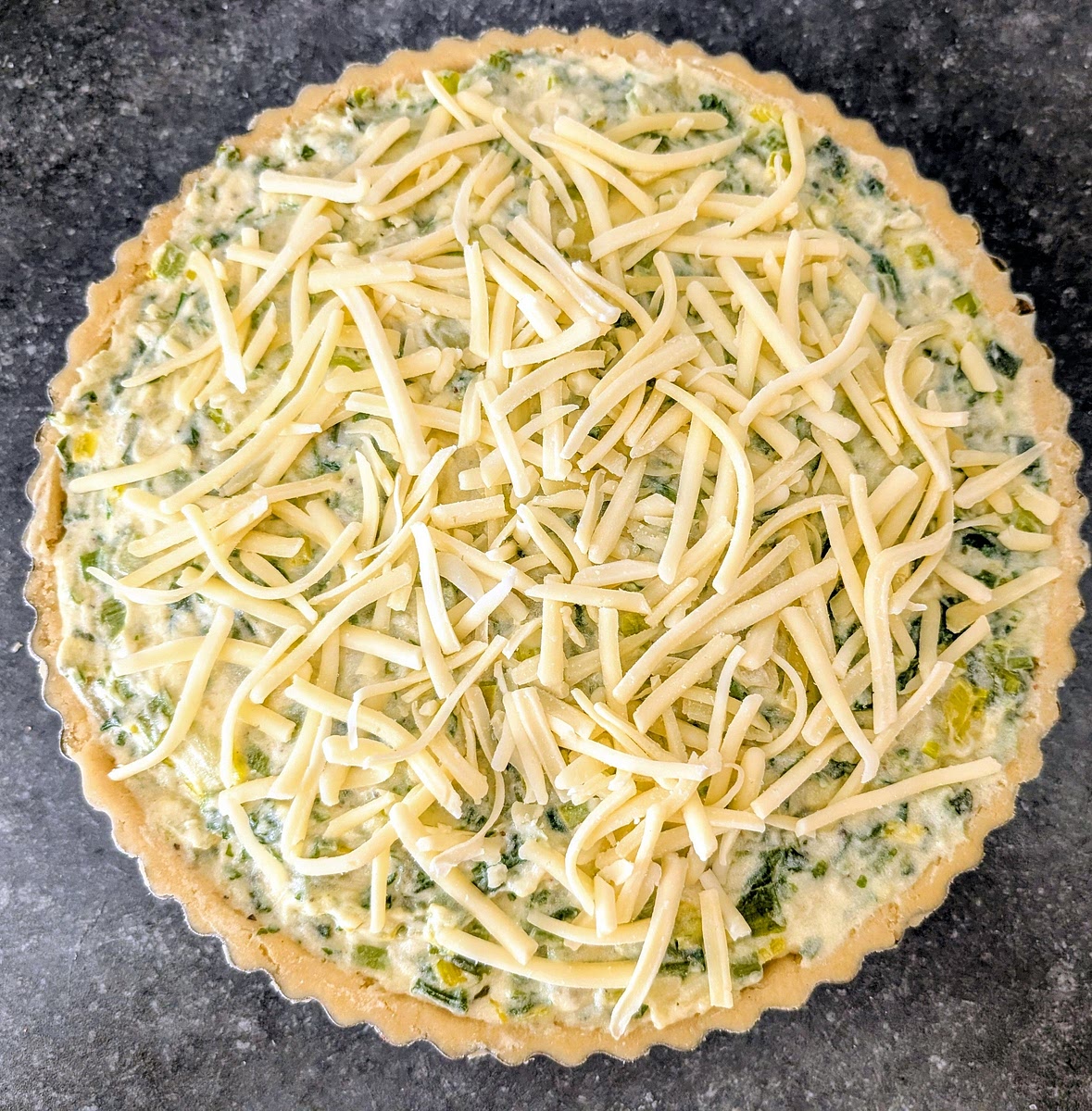 Tip the filling into the pastry case, press it out to the edges, then scatter over the remaining cheese.