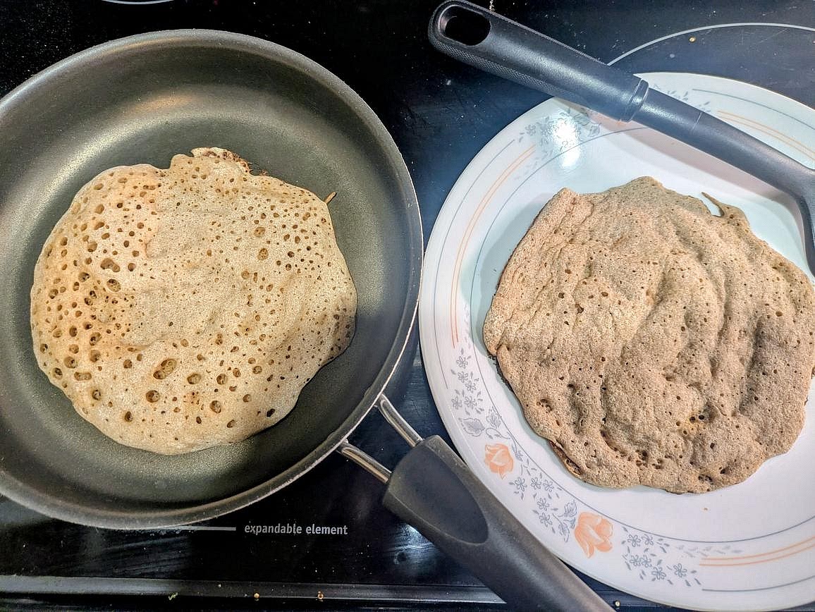 Return the pan to the burner over medium heat. Cook for about 2 minutes, or until the top side is dry, has small holes, and has lightly risen, and the bottom is lightly browned. Use a spatula to remove it to a plate. Repeat with the other flatbread