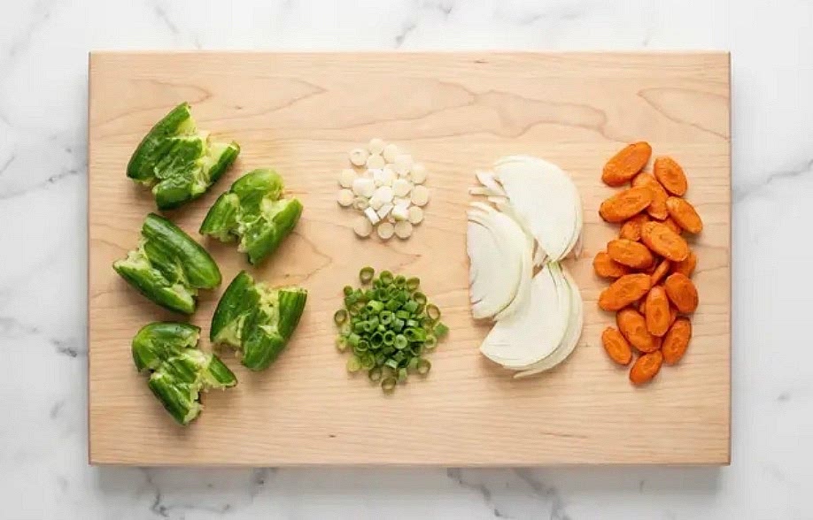 While rice cooks, wash and dry produce. Halve cucumbers lengthwise. Place under a plate; press down until cucumbers break open. Chop into 1-inch pieces. Trim and thinly slice scallions, separating whites from greens. Trim, peel, and cut carrots on a diagonal into ¼-inch-thick pieces. Halve, peel, and thinly slice onion.