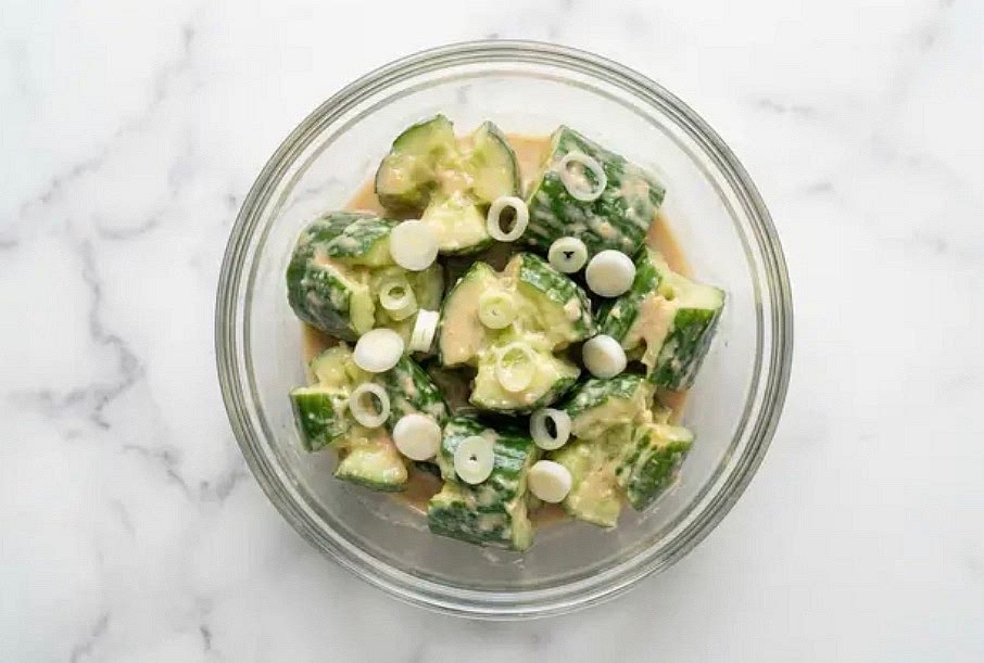 In a medium bowl, combine smashed cucumbers, scallion whites, miso ginger dressing, and ½ tsp sugar(1 tsp for 4 servings). Season with salt and pepper. Set aside to marinate, stirring occasionally, until ready to serve.