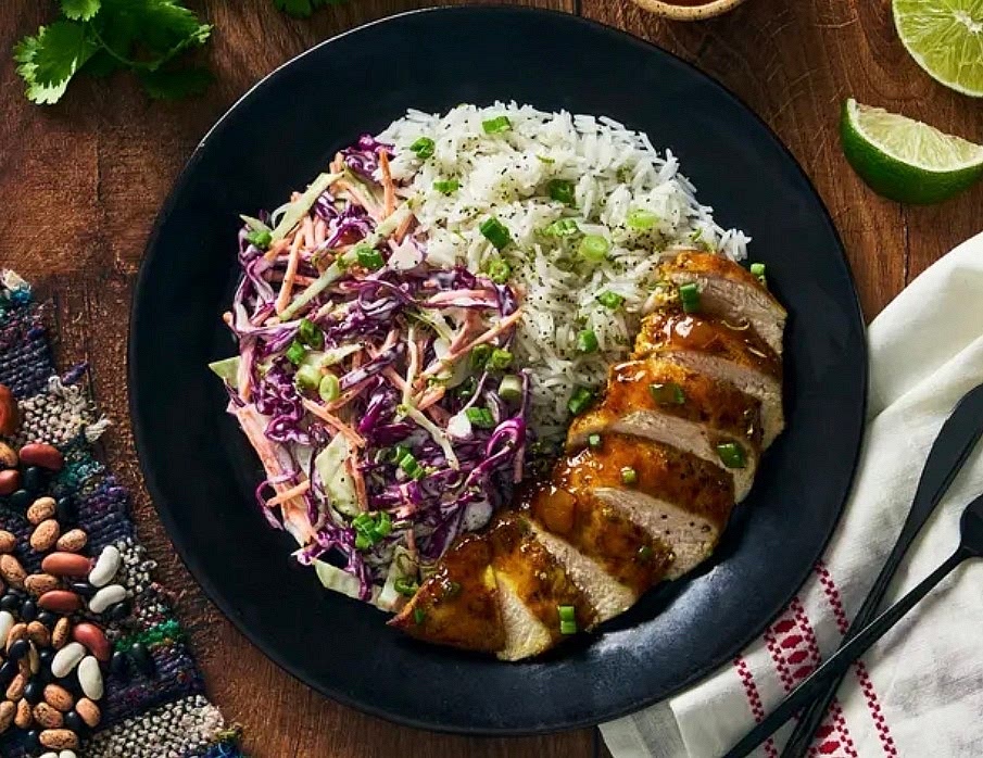 Thinly slice chicken.
Divide rice, chicken and coleslawbetween plates.
Spoon glaze from the pan over chicken and sprinkle with remaining green onions.
Squeeze a lime wedge over top.