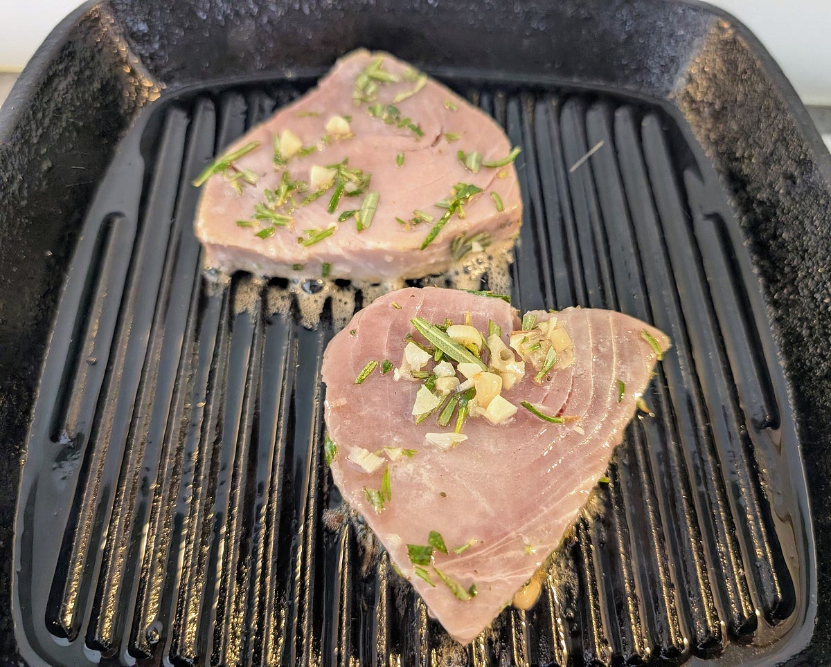 Heat the griddle (cast iron is best) until it starts to smoke, then add the tuna straight from the marinade, with the garlic and rosemary still on it. Cook for 1 1/2 minutes without touching it so you get tidy griddle marks on it.