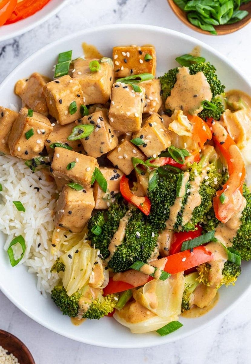 5. Assemble the Bowls
Layer:
Coconut jasmine rice
Stir fry vegetables
Crispy tofu
Peanut sauce
Then top with:
Hot Honey Chili Crunch
Green onion
Crushed peanuts
Lime squeeze