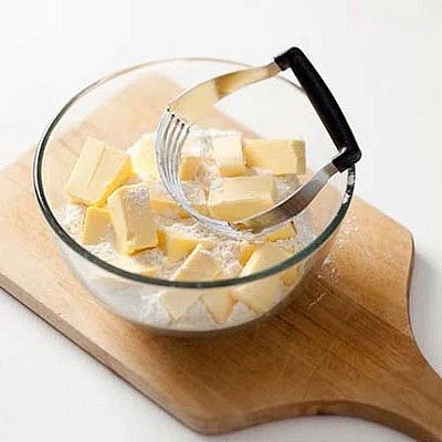 Sift flour twice and cut in the butter with a small knife, a pastry blender (illustrated) or your fingertips. Be very careful if using a food processor, it is inclined to transform the dough into a paste within seconds. The knobs of butter should remain as big a peas, and never get as small as breadcrumbs, or worse, a paste.