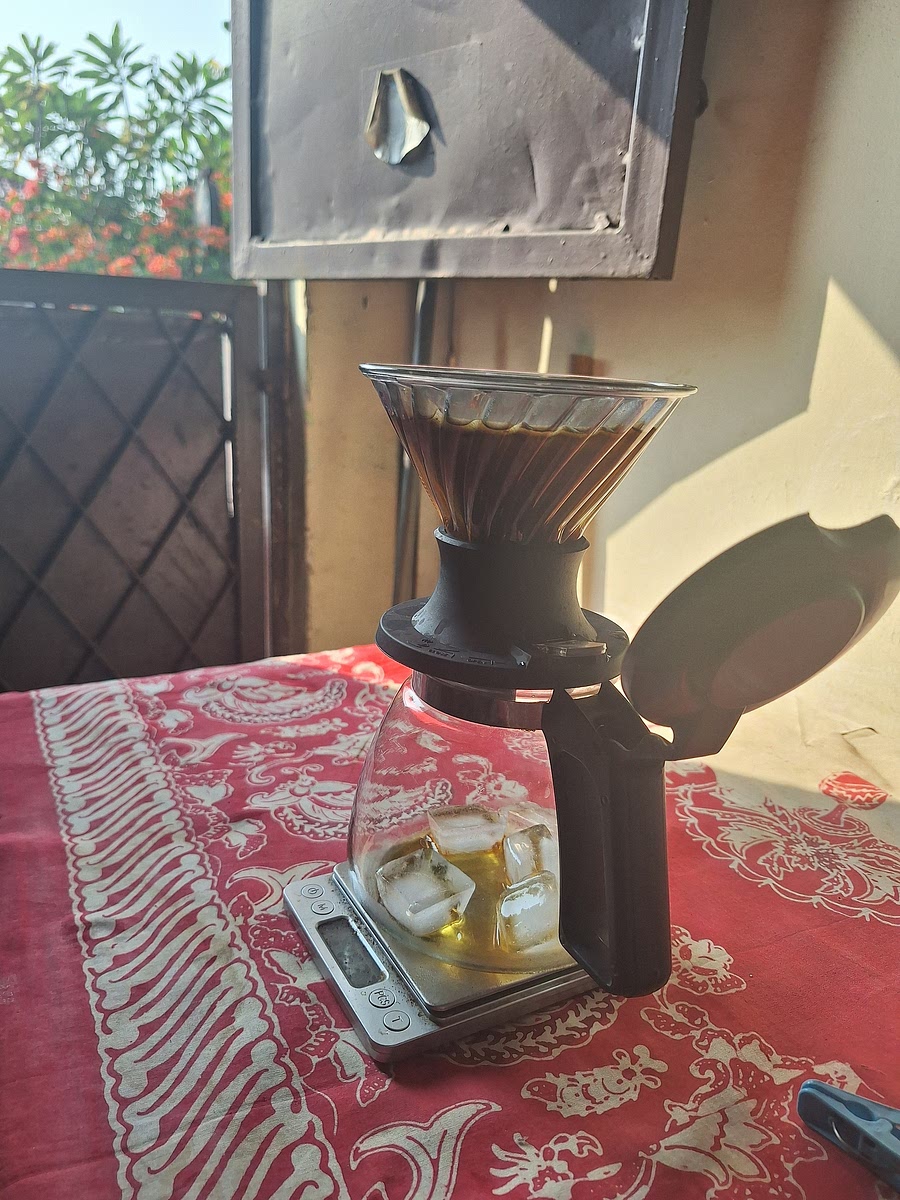 After 5 minutes, place dripper on server and open valve to let coffee drip onto ice.