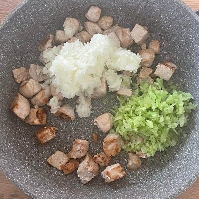 Reduce the heat to medium and add 1 finely diced onion and 2 finely diced celery stalks to the pork and cook for 2 minutes