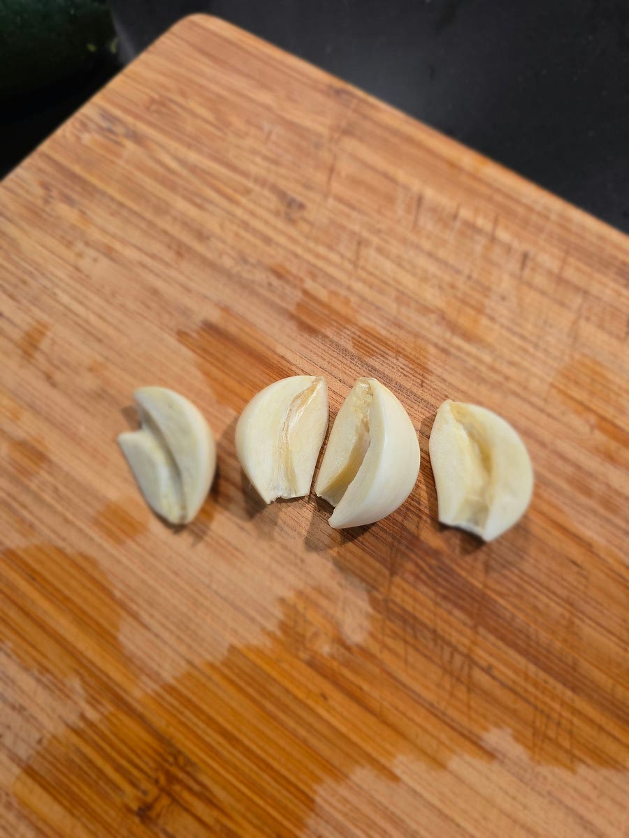 Snijd de knoflook tenen door de helft en verwijder het midden stuk