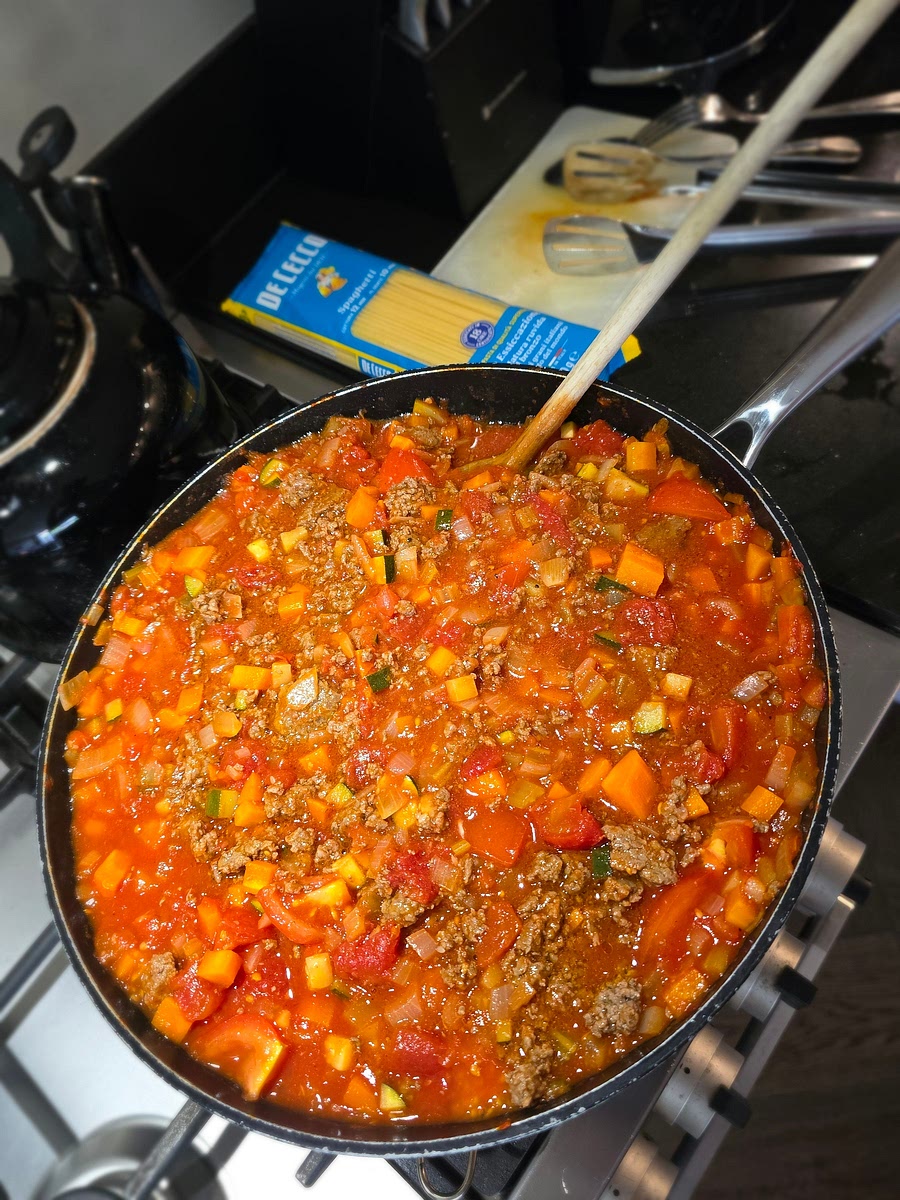 Op het moment dat het gerecht voldoende klaar is (na een uur of 2 bijvoorbeeld) schep ik de helft er uit voor in de vriezer. Dat scheelt weer een keer koken door de weeks. Je ziet nu dat er in de pan voldoende ruimte is om de kort gekookte al dente pasta af te garen in de saus. Dat gaan we nu doen.