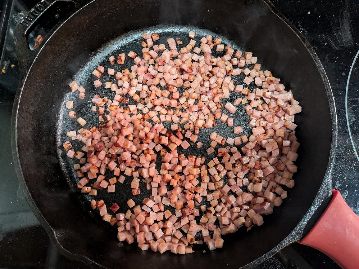 Preheat your oven to 400F. Heat a 10" cast iron pan on the stove over medium heat. Cut your ham into small cubes. When the pan is hot, add in the ham, and cook for about 5 minutes, or until the outside is lightly browned
