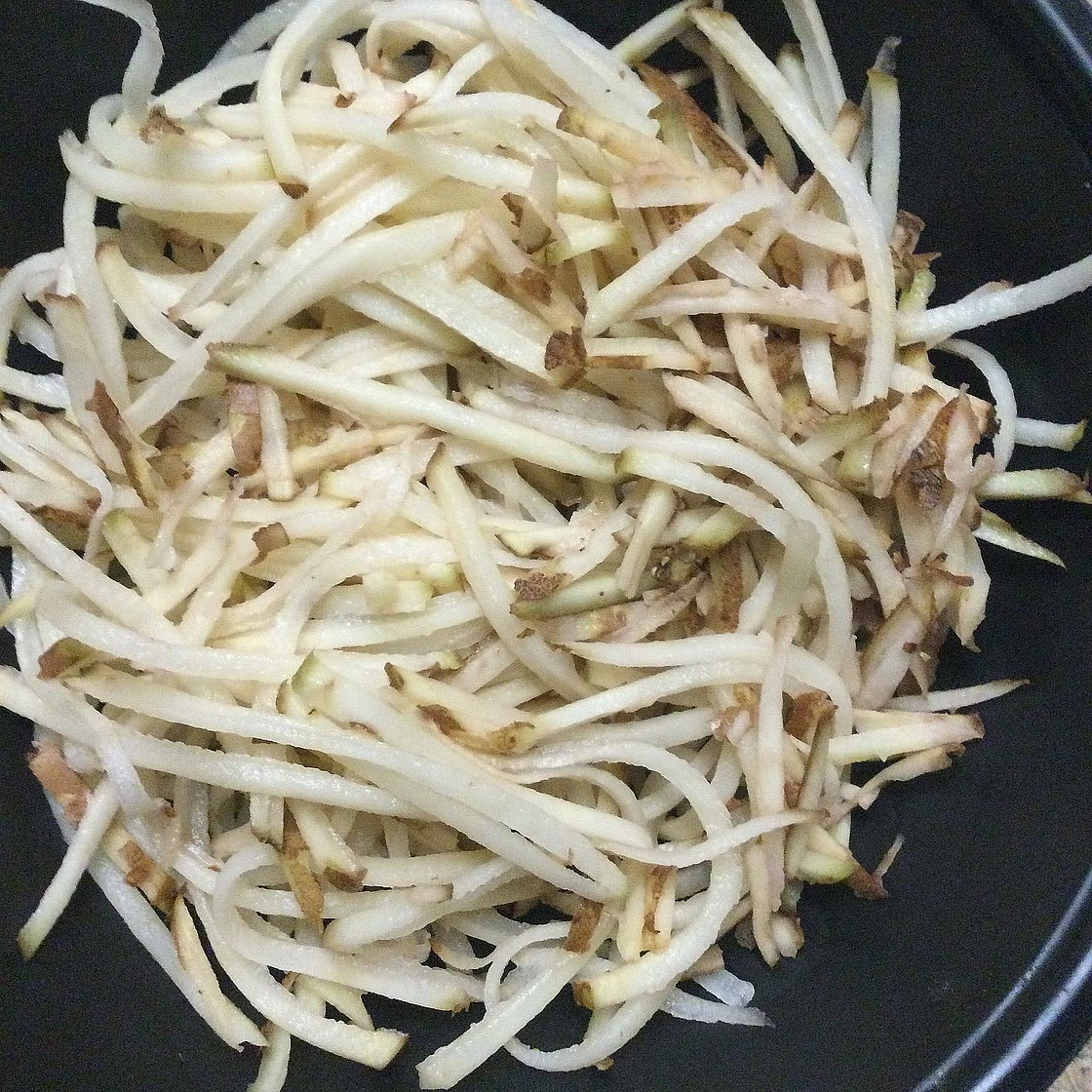 Put shredded potatoes in a bowl.