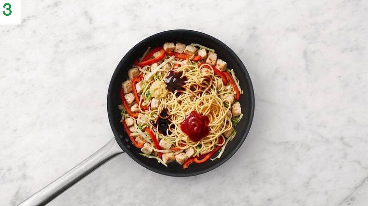 Once the chicken has cooked, add the noodles, ginger puree, oyster sauce,
Worcester sauce, soy, tomato ketchup and honey
Toss together to combine.
