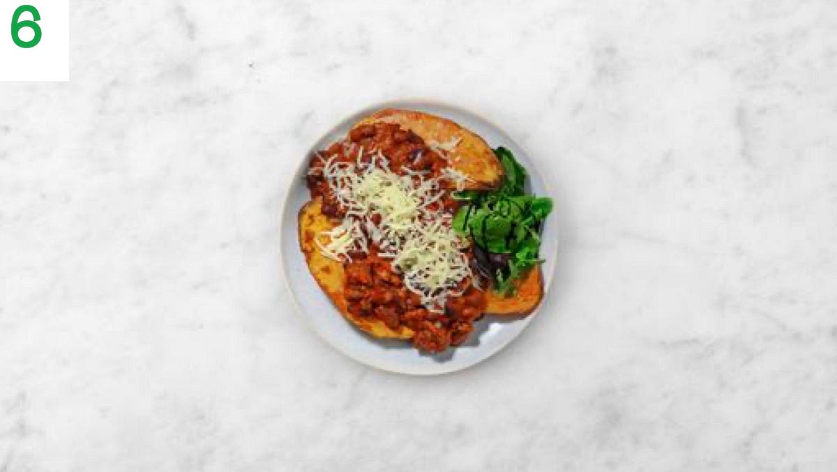 Share the sweet potato halves between your plates and spoon the beef and pork chilli on top.
Scatter over the cheese.
Serve the baby leaf salad on the side with the balsamic glaze drizzled over.
