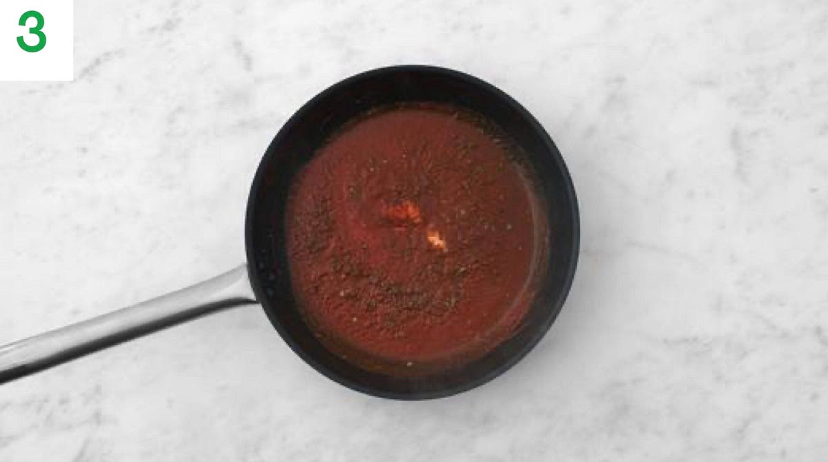 While everything cooks, heat a drizzle of oil in a large frying pan on medium-high heat.
Once hot, add the remaining garlic and fry for 1 min.
Stir in the remaining mixed herbs, the passata, red wine stock paste, sugar and water for the sauce.
Bring to the boil, then reduce the heat to medium so the sauce is simmering.
Cook, stirring occasionally, until slightly thickened, 4-5 mins.