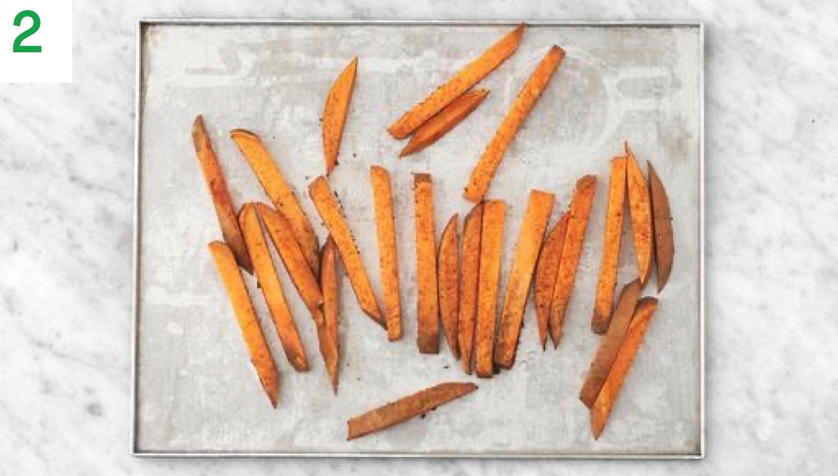 Meanwhile, chop the sweet potatoes lengthways into 1 cm slices, then chop into 1 cm wide fries (no need to peel).
Pop the fries onto a large baking tray. Drizzle with oil, season with salt and pepper, sprinkle over the Central American style spice mix, then toss to coat. Spread out in a single layer. TIP: Use two baking trays if necessary. Roast on the top shelf until golden, 25-30 mins. Turn halfway through.