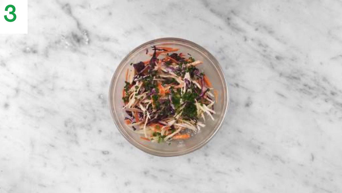 While everything's in the oven, zest and halve the lime.
Finely chop the chives (use scissors if easier).
In a medium bowl, combine the lime zest, sugar, half the lime juice and half the mayonnaise.
Add the sliced carrot and cabbage mix and half the chives to the bowl and toss to coat. Set aside.
