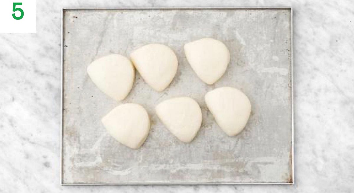 When the fries have 5 mins left, remove then, sprinkle over the hard Italian style cheese and toss to coat. Pop them back into the oven for the remaining time.
Meanwhile, place the bao buns on a plate, sprinkle with a little water and microwave, 800W: 1 min / 900W: 45 secs / 1000W: 30 secs.
If you don't have a microwave, place the bao buns onto a baking tray. Bake in the middle shelf until warm and fluffy, 2-3 mins.7