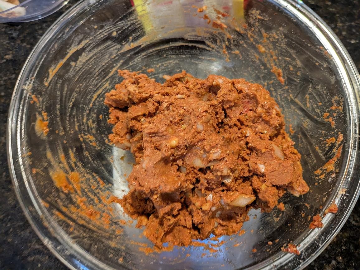 Add in the protein powder and nutritional yeast. Mix, and add in just enough water until you have a sticky "dough" that you can mold and shape with your hands