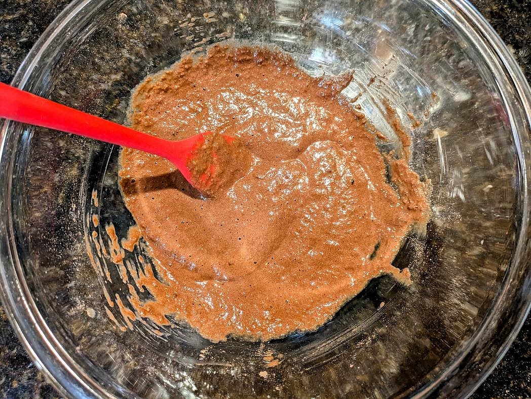 In a medium bowl, mix together the brownie ingredients with a silicone spatula until fully combined - applesauce, egg, whey, cocoa, baking powder, and salt.
