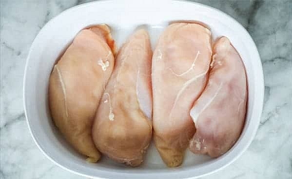 Lay the chicken breasts in a large casserole dish. You want a dish big enough so they aren’t crammed in and can lie flat. The fuller the dish is, the longer it will take to bake. Spread the cream cheese mixture over the top of the chicken and sprinkle remaining cheese evenly over the top.
*You can cut the chicken in half, into chunks, or use chicken tenderloins instead of full chicken breasts to make serving easier. Cooking time may be reduced.*