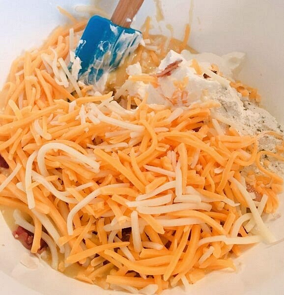 Combine chicken, soup, sour cream, 1 cup grated cheese, Ranch dressing mix, and bacon.