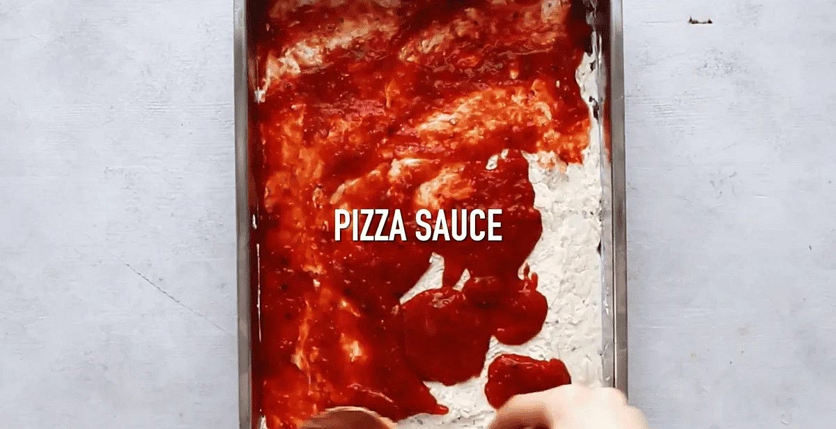 Spread pizza sauce evenly over the cheese mixture.