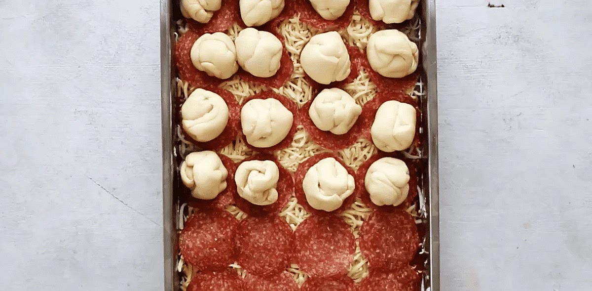 Divide the dough into the same number of sections as the number of pepperoni slices used. Roll the dough sections into balls and place on a each slice of pepperoni.