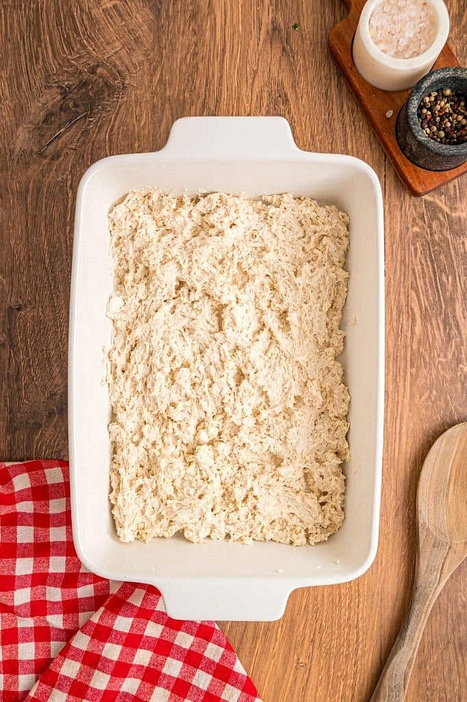 In a medium bowl, prepare the biscuit dough by combining 1 box Red Lobster Cheddar Bay Biscuit Mix (including the seasoning packet) and 3/4 cup cold water. Mix until just combined. Spread the dough evenly across the bottom of the prepared casserole dish. If you find it too sticky to spread, just spray your clean hands with a little cooking spray, spread it out, and gently press it down a little.
