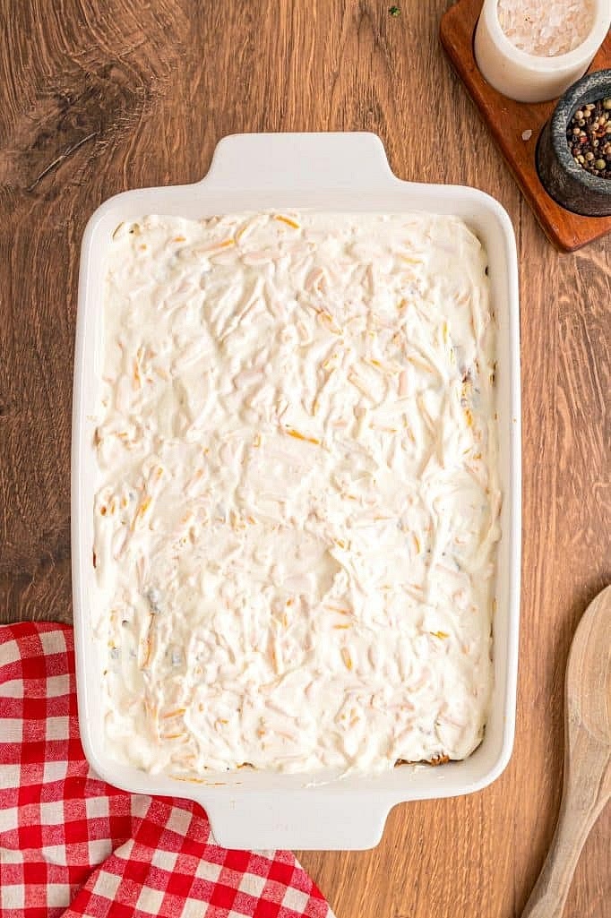 In a small bowl, combine 1/2 cup mayonnaise, 1/2 cup sour cream, and 1 cup shredded Colby Jack cheese. Spread this mixture evenly over the beef layer.