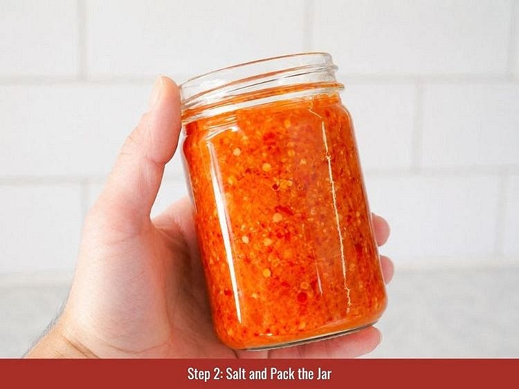 Weigh the pepper mash and mix it with fine sea salt at a 30:1 pepper-to-salt ratio. For 1 lb (450 g) of pepper mash, use 1 tbsp (15 g) of salt. Stir thoroughly, then transfer the salted mash to clean glass Mason jars. Leave enough space at the top for gases to expand during fermentation.