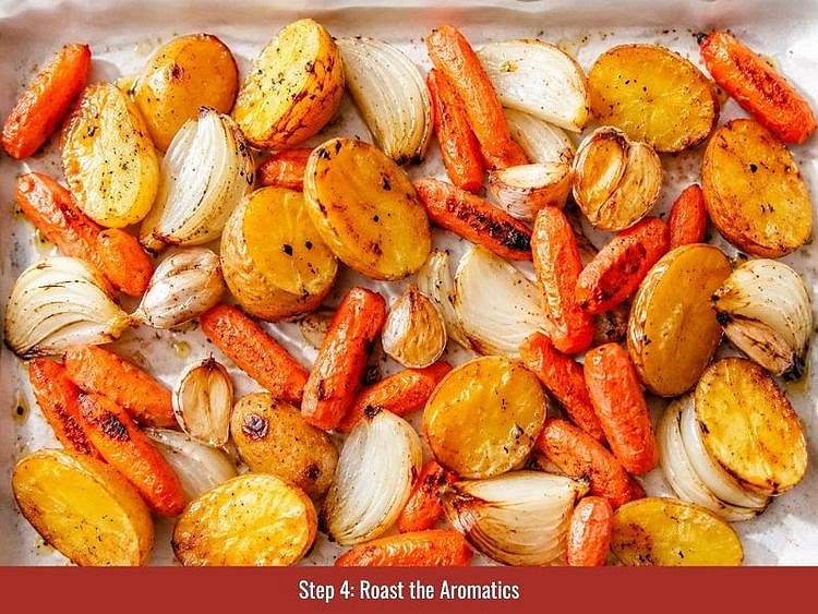 Preheat the oven to 400°F (200°C). Place the carrots, onions, and garlic on a sheet of foil set over a baking tray. Drizzle with olive oil, seal the foil into a packet, and roast for approximately 40 minutes, or until the vegetables are completely tender. Transfer the roasted vegetables to a food processor and blend until smooth.