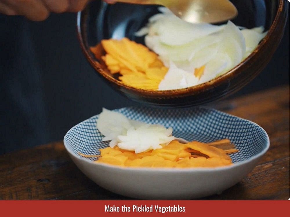 Prepare The Pickled Vegetables
Combine the sliced carrot and green papaya or kohlrabi with 1 tablespoon of salt. Let the vegetables sit for 10 minutes, then drain and squeeze out the excess liquid. Mix the vegetables with sugar, vinegar, and minced garlic to taste. Add seeded cucumber slices if desired. Let the pickles rest at room temperature for 1–2 hours.