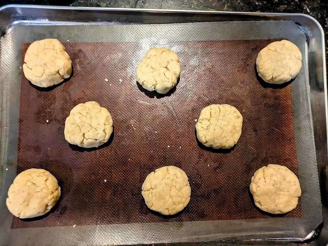 Divide the dough into 8 equal pieces, about 71 g each. Roll into balls, place on the cookie sheet, and lightly flatten.