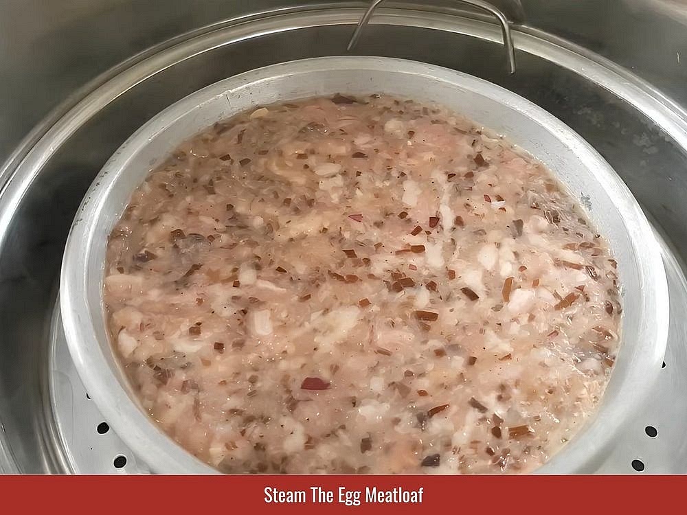 Steam The Egg Meatloaf
Line a heat-safe mold with banana leaf or plastic wrap. Transfer the meatloaf mixture into the mold, leaving approximately 1/2 inch (1 centimeter) of space at the top. Place the mold in a steamer over boiling water. Keep the lid slightly open during the first 3 minutes to prevent condensation from dripping onto the surface. Cover and steam for 20–25 minutes.