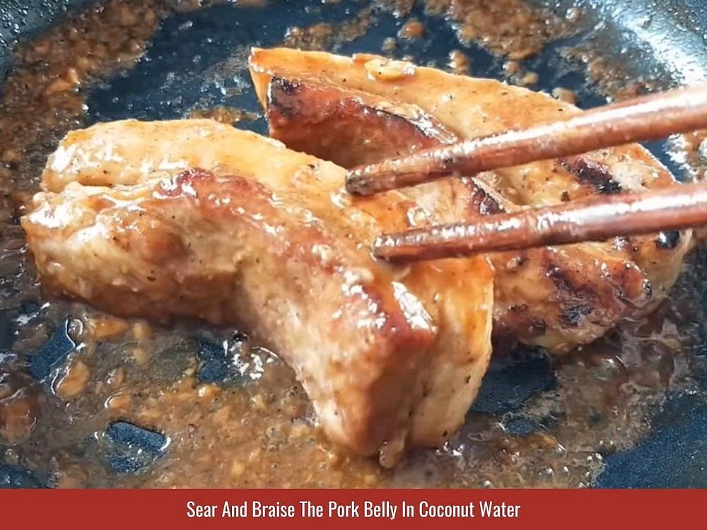 Sear And Braise The Pork Belly
Heat the cooking oil in a deep skillet over medium heat. Add the marinated pork belly and sear until browned on all sides. Pour in the coconut water and simmer, turning the pork every 2–3 minutes. Continue cooking until the liquid evaporates and the pork develops a sticky caramelized glaze. Let the pork belly cool completely before slicing.