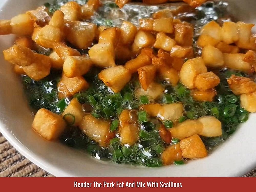 Render The Pork Fat And Mix With Scallions
Cut 8.8 oz (250g) skinless pork fat into ½-inch (1 to 1.5cm) cubes. Add them to a pan with ½ tbsp water and ⅓ tsp salt, then cook over high heat, stirring, until the fat renders and the solids shrink and turn golden. Pour the hot fat and crisp bits straight over 1.8 oz (50g) sliced scallions in a bowl. Toss it right away, since the heat wilts the scallions and lifts their aroma. Taking the skin off the fat first stops the splattering and speeds up the process. Keep the crispy cubes too; the pork fat “tóp mỡ” is a topping, not a waste.