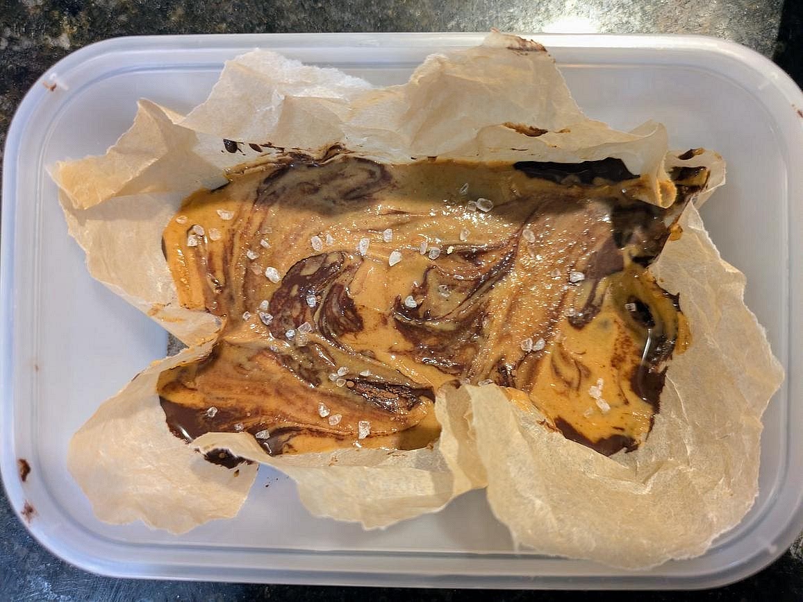 Line a small container with parchment paper. Add the chocolate mixture to the bottom, then the peanut butter on top. Lightly swirl together. Optionally top with flaky salt.