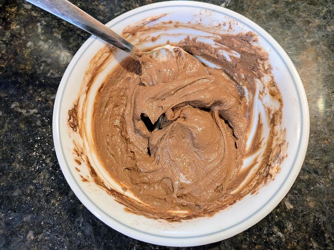 Add yogurt, powdered peanut butter, whey, and cocoa powder to a small bowl. Mix with a silicone spatula, and thin out to desired consistency with almond milk.
