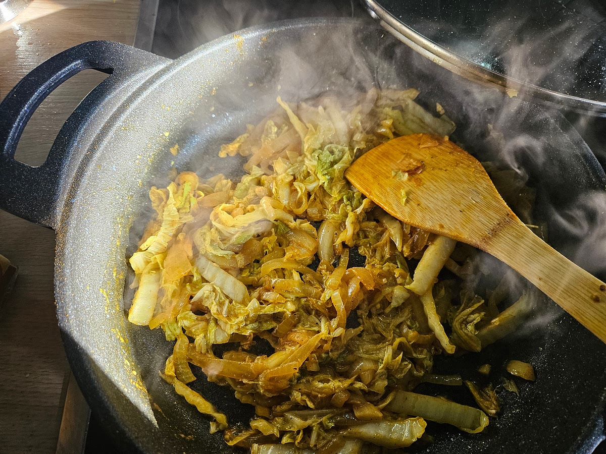 Add the finely sliced Chinese cabbage. Increase the heat to medium-high and toss thoroughly so the cabbage is coated in the onion, oil and spices.
Cook uncovered for 5–7 minutes, stirring frequently.